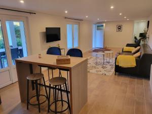 a living room with a kitchen and a living room with a couch at Appartement au cœur du golf in Pont-de-Larn +2 photos