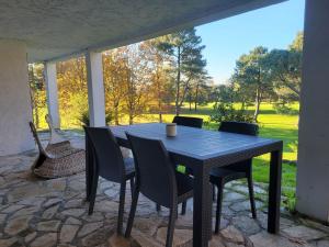 a black table and chairs on a patio at Appartement au cœur du golf in Pont-de-Larn