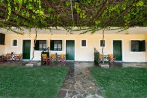 a building with tables and chairs in a yard at Villa Panorama in Moúdhros