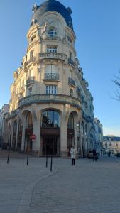 a large building with a woman standing in front of it at Chez Marie in Vannes