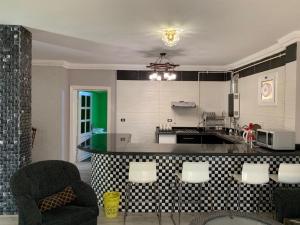 a kitchen with a counter and chairs in a room at cozy penthouse in New Cairo in Al Khārijah