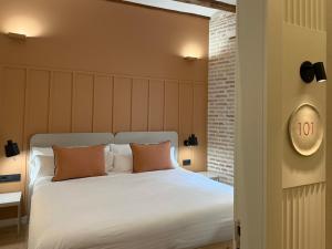 a bedroom with a large white bed with two pillows at Cosy Rooms Embajador in Valencia