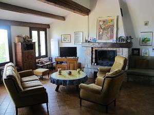 a living room with chairs and a table and a fireplace at La vue sur mer in La Croix-Valmer