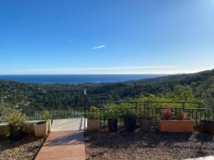 a view of the ocean from a house with potted plants at La vue sur mer in La Croix-Valmer