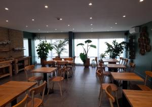 a restaurant with wooden tables and chairs and plants at Les Jardins de L'Ocean - Climatisé in Biscarrosse-Plage