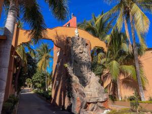 a statue in front of a building with palm trees at Hotel Oasis in Mazatlán
