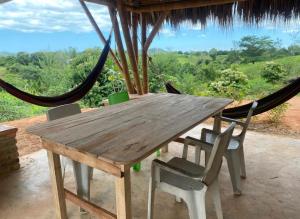une table et des chaises en bois sur un porche avec un hamac dans l'établissement Casa Akasha, à Mingueo 9 autres photos