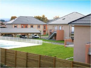 a view of a yard with houses and a fence at T3 duplex with garden in Arpajon-sur-Cère
