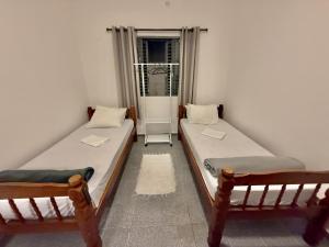 two twin beds in a room with a window at Pousada Family Consulado Americano in São Paulo
