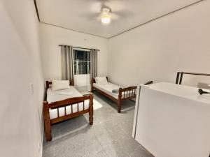 a room with two beds and a window at Pousada Family Consulado Americano in São Paulo
