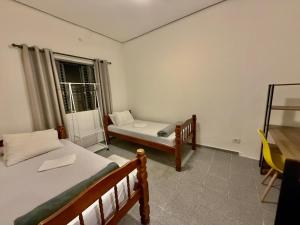 a bedroom with two beds and a window at Pousada Family Consulado Americano in São Paulo