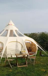 Tienda con 2 sillas y mesa en el césped en Stargazer Bell Tent, en Northrepps