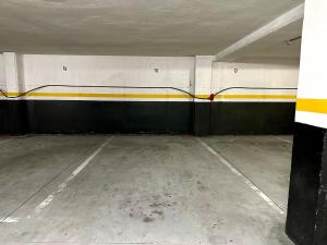 an empty parking garage with a train painted on the wall at El pisito de Carmen in Portosin