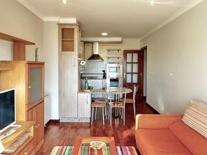 a living room with a table and a kitchen at El pisito de Carmen in Portosin
