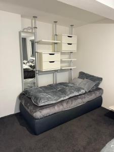 a bed in a room with a shelf and a mirror at Your flat in Vohenstrauß