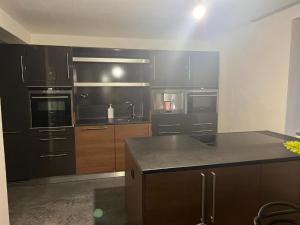 a kitchen with black appliances and wooden cabinets at Your flat in Vohenstrauß