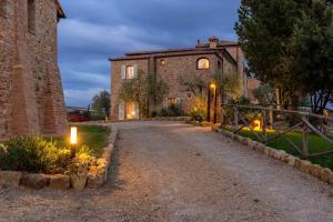 a stone house with lights on the side of a road at Suite Leonardo in San Gimignano