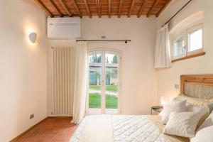 a bedroom with a bed and a large window at Suite Leonardo in San Gimignano +14 photos