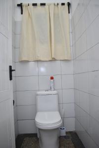 a white toilet in a bathroom with a window at La Casa Di Nico Studio Lillies Hse 5 in Mombasa