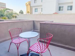 two pink chairs and a table on a patio at Charming 2nd Ave Lofts in Downtown San Diego with Parking in San Diego