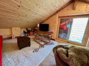 a living room with a couch and a television at Charmant chalet authentique de montagne Bleusy- Nendaz idéal couple et famille in Saclentse