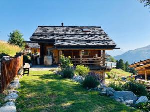 a small log cabin with a garden in front of it at Charmant chalet authentique de montagne Bleusy- Nendaz idéal couple et famille in Saclentse