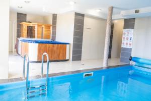 シオーフォクにあるCAC Wellness Apartmentのバスタブ付きのホテルルームのプールを利用できます。
