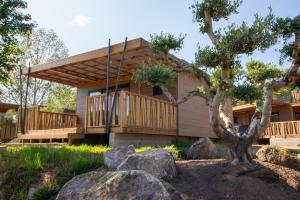 a house with a deck and a tree at U Pinarellu in Zonza