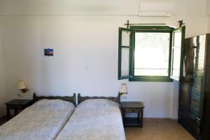 a bedroom with two beds and a window at Villa Panorama in Moúdhros