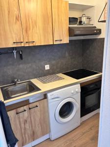 a kitchen with a washing machine and a sink at Appartement secteur village rez-de-chaussée avec terrasse et parking 50m mer in Le Barcarès