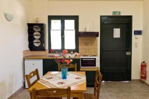 a kitchen with a table with a vase of flowers on it at Villa Panorama in Moúdhros