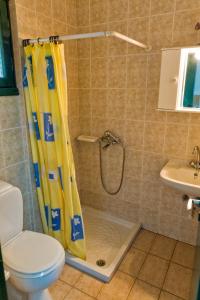 a shower with a yellow shower curtain in a bathroom at Villa Panorama in Moúdhros +37 photos
