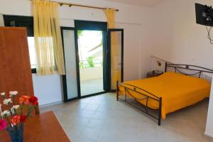 a bedroom with a yellow bed and a table at Villa Panorama in Moúdhros
