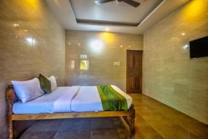 a bedroom with a bed in a room with a tv at Calangute Sea Steps in Calangute