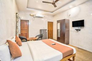 a hotel room with a bed and a tv at Calangute Sea Steps in Calangute