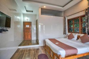 a bedroom with a bed and a tv in it at Calangute Sea Steps in Calangute