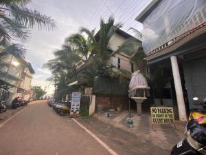 a street with a palm tree and a building at Calangute Sea Steps in Calangute
