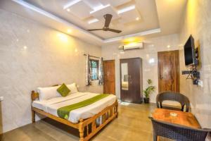 a bedroom with a bed and a table and a tv at Calangute Sea Steps in Calangute