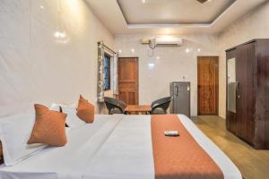 a bedroom with a large white bed with orange pillows at Calangute Sea Steps in Calangute