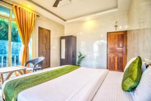 a bedroom with a large white bed and a table at Calangute Sea Steps in Calangute