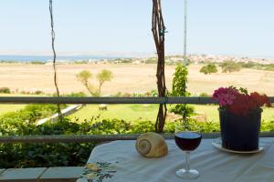a glass of wine sitting on a table with a view at Villa Panorama in Moúdhros