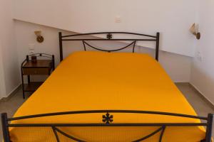 a large yellow bed in a room with at Villa Panorama in Moúdhros