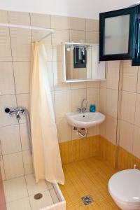 a bathroom with a sink and a shower and a toilet at Villa Panorama in Moúdhros