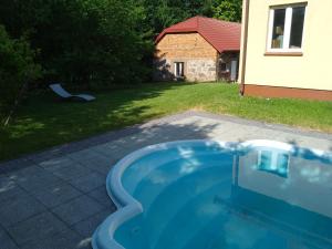 a swimming pool in a yard with a house at Gospodarstwo Agroturystyczne Wólka 34 in Filipów