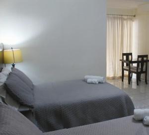 une chambre avec un lit, une table et des chaises dans l'établissement Kartagus Centric, à San Salvador