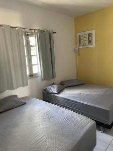 a bedroom with two beds and a window at Casa de Praia Tamandaré in Tamandaré