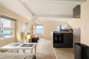 Una sala de estar con una mesa y una cocina. en T2 dans l'intra-Muros VUE MER exceptionnelle, en Saint-Malo
