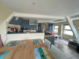 Una cocina y una sala de estar con una mesa de madera. en T2 dans l'intra-Muros VUE MER exceptionnelle, en Saint-Malo