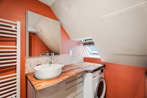 a bathroom with a sink and a washing machine at T2 dans l'intra-Muros VUE MER exceptionnelle in Saint Malo