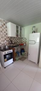 eine Küche mit einem weißen Kühlschrank und einem Herd in der Unterkunft Yellow House Itapuama in Cabo de Santo Agostinho